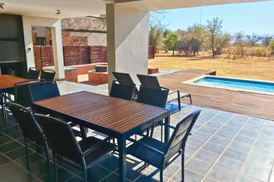 a patio with a table and chairs and a pool at Zebula Bush Villa 82, Zebula Golf Estate and Spa in Mabula