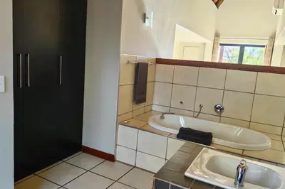 a bathroom with a bath tub and a sink at Zebula Bush Villa 82, Zebula Golf Estate and Spa in Mabula