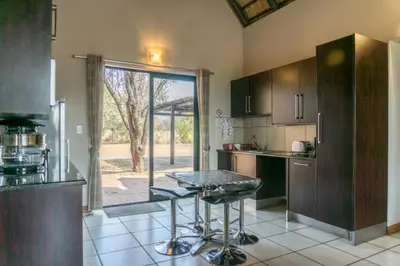 a kitchen with a counter and a table in it at Zebula Bush Villa 82, Zebula Golf Estate and Spa in Mabula