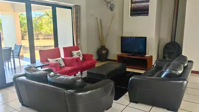 a living room with leather couches and a flat screen tv at Zebula Bush Villa 82, Zebula Golf Estate and Spa in Mabula