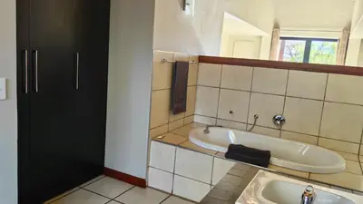 a bathroom with a bath tub and a sink at Zebula Bush Villa 82, Zebula Golf Estate and Spa in Mabula