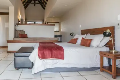 a large bedroom with a large bed and a table at Zebula Bush Villa 82, Zebula Golf Estate and Spa in Mabula