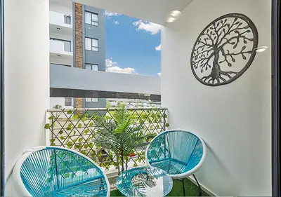 a balcony with two chairs and a clock on the wall at Zalari Luxe 93 on New, Carlswald, Midrand in Midrand