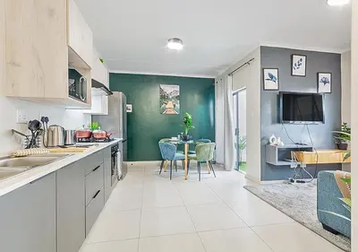a kitchen with a table and a dining room at Zalari Luxe 93 on New, Carlswald, Midrand in Midrand