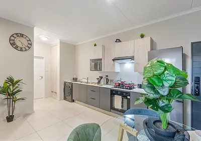 a kitchen with a table and a clock on the wall at Zalari Luxe 93 on New, Carlswald, Midrand in Midrand
