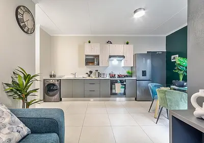 a kitchen and living room with a couch and a table at Zalari Luxe 93 on New, Carlswald, Midrand in Midrand
