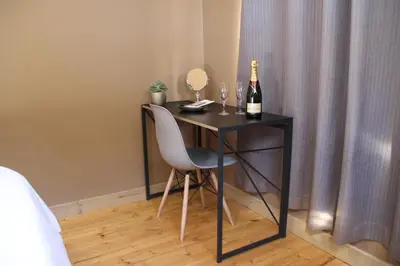a black table with a bottle of wine and a chair at Romantic cabin in Big 5 Reserve in Dinokeng Game Reserve