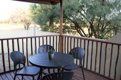 a blue table and chairs on a wooden deck at Romantic cabin in Big 5 Reserve in Dinokeng Game Reserve