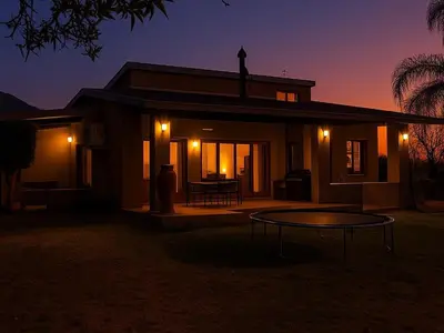 a house with a table in front of it at night at The Sanctuary- Self Catering Accommodation in Nelspruit