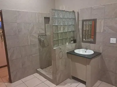 a bathroom with a shower and a sink at The Sanctuary- Self Catering Accommodation in Nelspruit