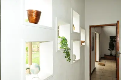 a hallway with white walls and a window with a plant at The Sanctuary- Self Catering Accommodation in Nelspruit