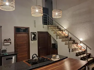 a kitchen with a spiral staircase with two lights at The Sanctuary- Self Catering Accommodation in Nelspruit