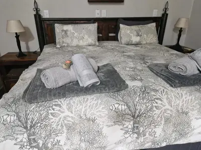 a bed with towels and a teddy bear on it at Heavenly Hideaway Accommodation in Kampersrus AH