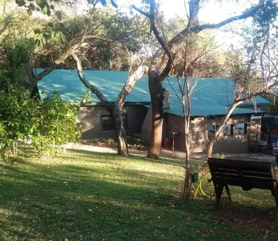 a house with a bench in front of a yard at Heavenly Hideaway Accommodation in Kampersrus AH