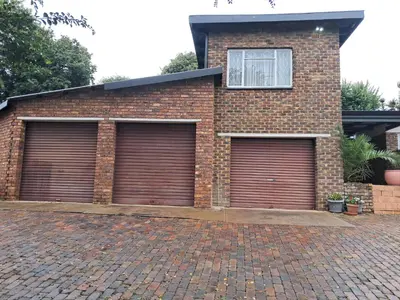 a brick house with three garage doors on it at 15 Kameeldoring 2-bedroomed self-catering unit, Clubview in Centurion