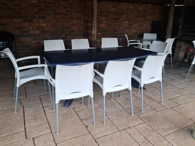 a black table and white chairs on a patio at 15 Kameeldoring 2-bedroomed self-catering unit, Clubview in Centurion