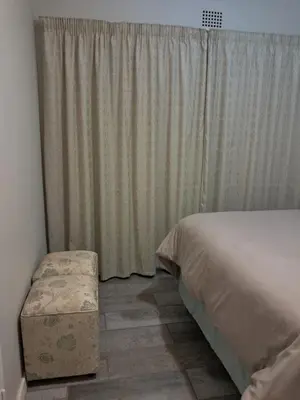 a bedroom with a bed and a chair next to a window at 15 Kameeldoring 2-bedroomed self-catering unit, Clubview in Centurion