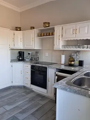 a kitchen with white cabinets and a black dishwasher at 15 Kameeldoring 2-bedroomed self-catering unit, Clubview in Centurion