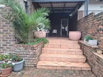 a brick walkway with potted plants on it at 15 Kameeldoring 2-bedroomed self-catering unit, Clubview in Centurion