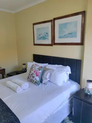a bed with two pillows and two towels on it at Choosers Express Boutique Hotel Room 4 in Centurion