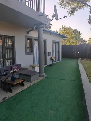 a backyard with a green lawn and a house at Choosers Express Boutique Hotel Room 4 in Centurion