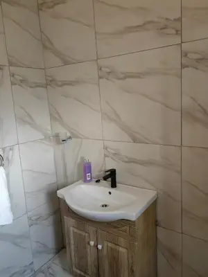 a white sink in a bathroom with marble walls at Choosers Express Boutique Hotel Room 4 in Centurion
