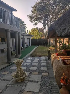 a garden with a fountain in the middle of a yard at Choosers Express Boutique Hotel Room 4 in Centurion
