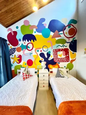 two beds in a room with a colorful wall at Thornhill Tranquility in Pretoria