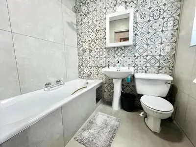 a bathroom with a toilet and a bath tub and a sink at Thornhill Tranquility in Pretoria