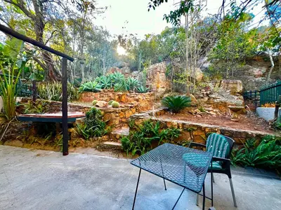 a patio with a table and chairs in a garden at Thornhill Tranquility in Pretoria