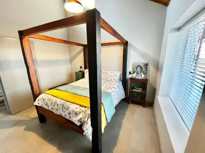 a bedroom with a canopy bed and a mirror at Thornhill Tranquility in Pretoria