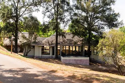 a white house with trees in front of it at Kianga Lodge & Venue in Centurion