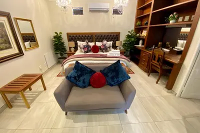 a bedroom with a bed with a couch and a desk at Waterkloof Guest House in Pretoria