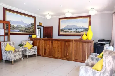 a waiting room with yellow pillows and chairs at Waterkloof Guest House in Pretoria