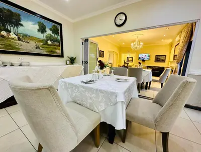 a dining room with a white table and chairs at Waterkloof Guest House in Pretoria
