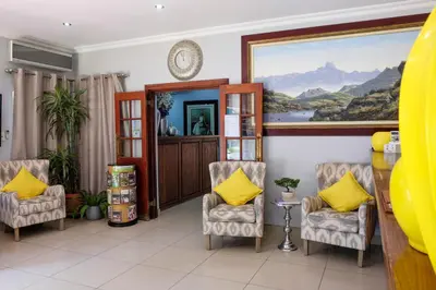 a waiting room with chairs and a painting on the wall at Waterkloof Guest House in Pretoria