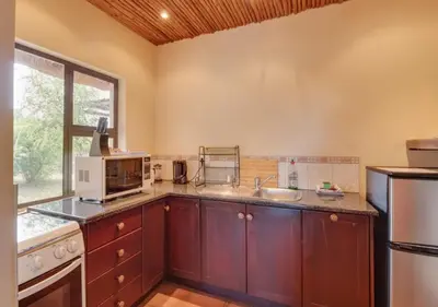 a kitchen with a sink and a microwave at 205 Zebula 4 Bedroom with 2 bedroom Cottage in Mabula