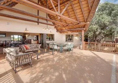 an outdoor living room with a table and chairs at 205 Zebula 4 Bedroom with 2 bedroom Cottage in Mabula