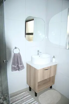 a bathroom with a sink and a shower at KT Nest in Midrand