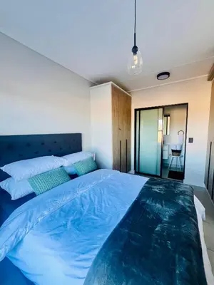 a bedroom with a large bed with blue sheets at The Blyde Bliss in Pretoria