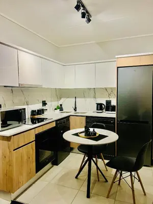 a kitchen with a table and a black refrigerator at The Blyde Bliss in Pretoria