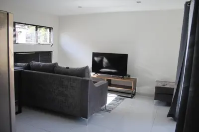 a living room with a couch and a flat screen tv at KT Space in Midrand