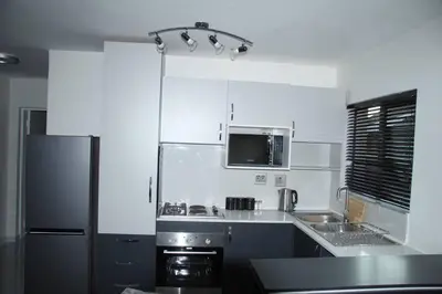 a kitchen with a refrigerator and a sink and a microwave at KT Space in Midrand