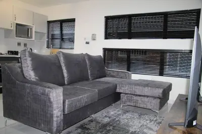 a gray couch in a living room with a window at KT Space in Midrand