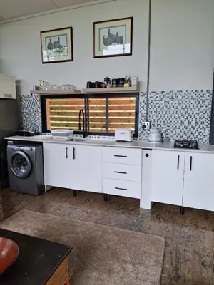 a kitchen with a sink and a washing machine at Modern Apartment on Letaba River in Tzaneen
