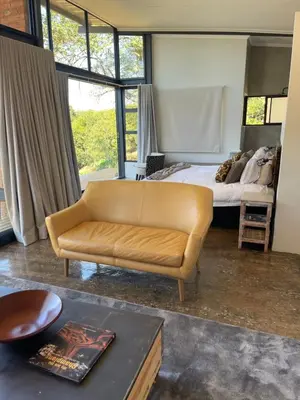 a living room with a couch and a bed at Modern Apartment on Letaba River in Tzaneen