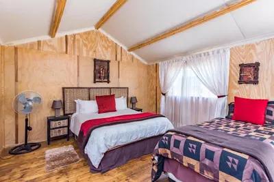 a bedroom with two beds and a window at Die Boskombuis en Gastehuis in Rayton