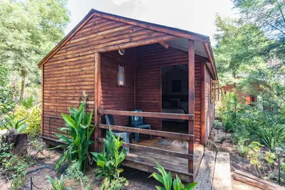 a small wooden cabin in the woods at Die Boskombuis en Gastehuis in Rayton