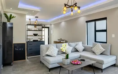 a living room with a couch and a table at Woman Era Guesthouse in Midrand