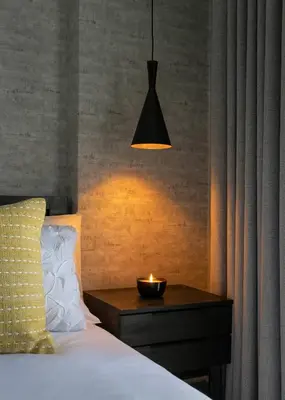 a bedroom with a bed with a candle on a table at Woman Era Guesthouse in Midrand